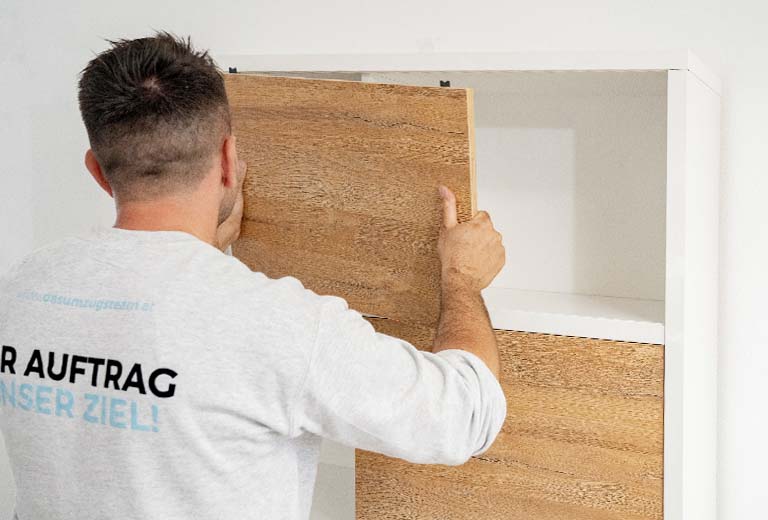 Erstklassgier Montageservice vom Profi - der top ausgebildete Mitarbeiter von DasUmzugsteam baut eine Schublade fachgerecht zusammen.