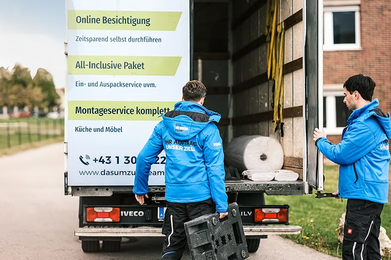 Möbelpacker stehen vor dem Umzugswagen