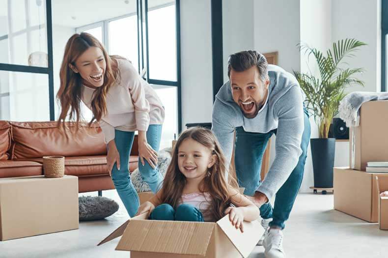 Ein privater Umzug einer Familie mit Mann, Frau und Kind im Umzugskarton.