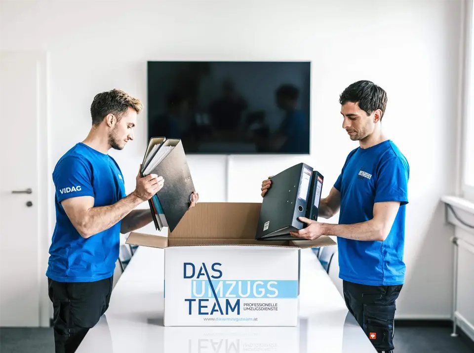 2 Männer verpacken Ordner - Firmenumzug Wien und Büroumzug