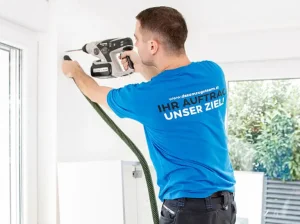 Mitarbeiter von DasUmzugsteam montiert fachgerecht einen Hochschrank an der Wand.