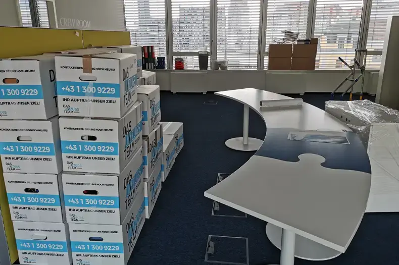 Firmenumzug Graz - Büromöbel und gepackte Kartons stehen bereit für den Umzug