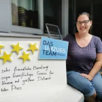 Kundenbewertung: einer jungen Frau sitzt neben einer Tafel mit 5 goldenen Sternen