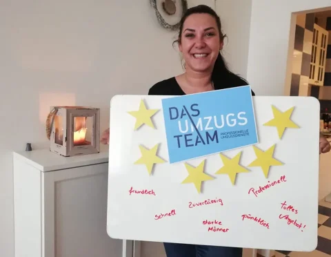Eine Frau hält eine Tafel in der Hand mit 4 goldenen Sternen
