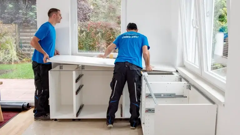 Küchenmontage: 2 Mitarbeiter unserer Umzugsfirma bauen eine Küche nach einem Umzug auf.
