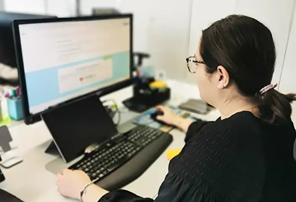 Umzug Wien: Eine Mitarbeiterin von DasUmzugsteam sitz vor einem Monitor und erstellt ein Angebot