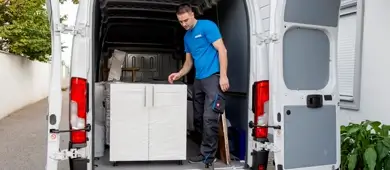 Möbelpacker Wien: 1 Möbelpacker lädt einen Kasten in einen Umzugswagten.