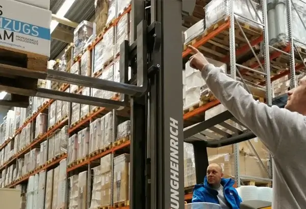 Zusatzleistungen Umzug: 2 Mitarbeiter von DasUmzugsteam lagern Kartons in einem Hochlager ein