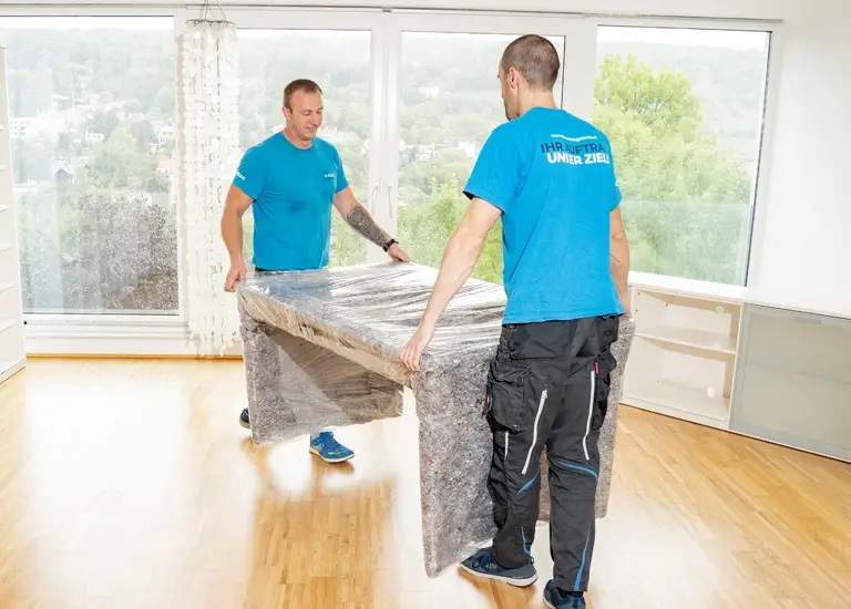 2 Möbelpacker tragen Schreibtisch
